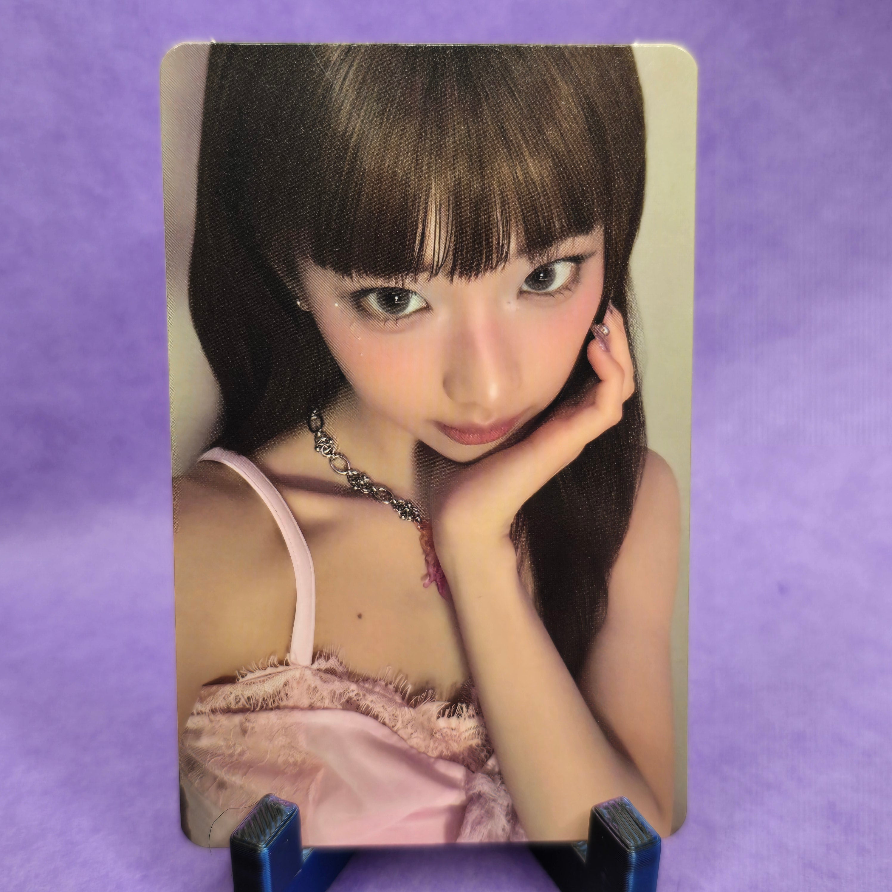 Card with a person wearing a pink lace garment on a purple background